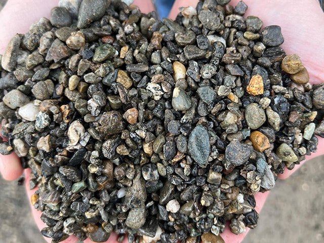 Two hands holding washed pea gravel