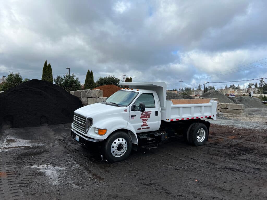 A white DC Materials dump truck in the yard